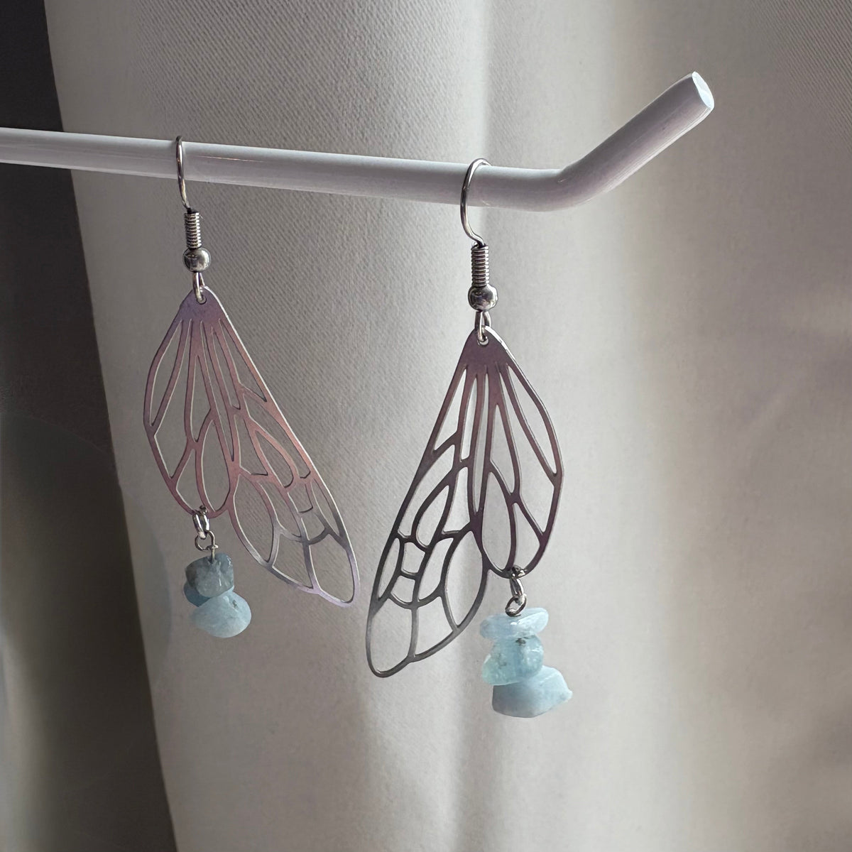 Stainless steel silver fairy wing dangle earrings with blue aquamarine crystals