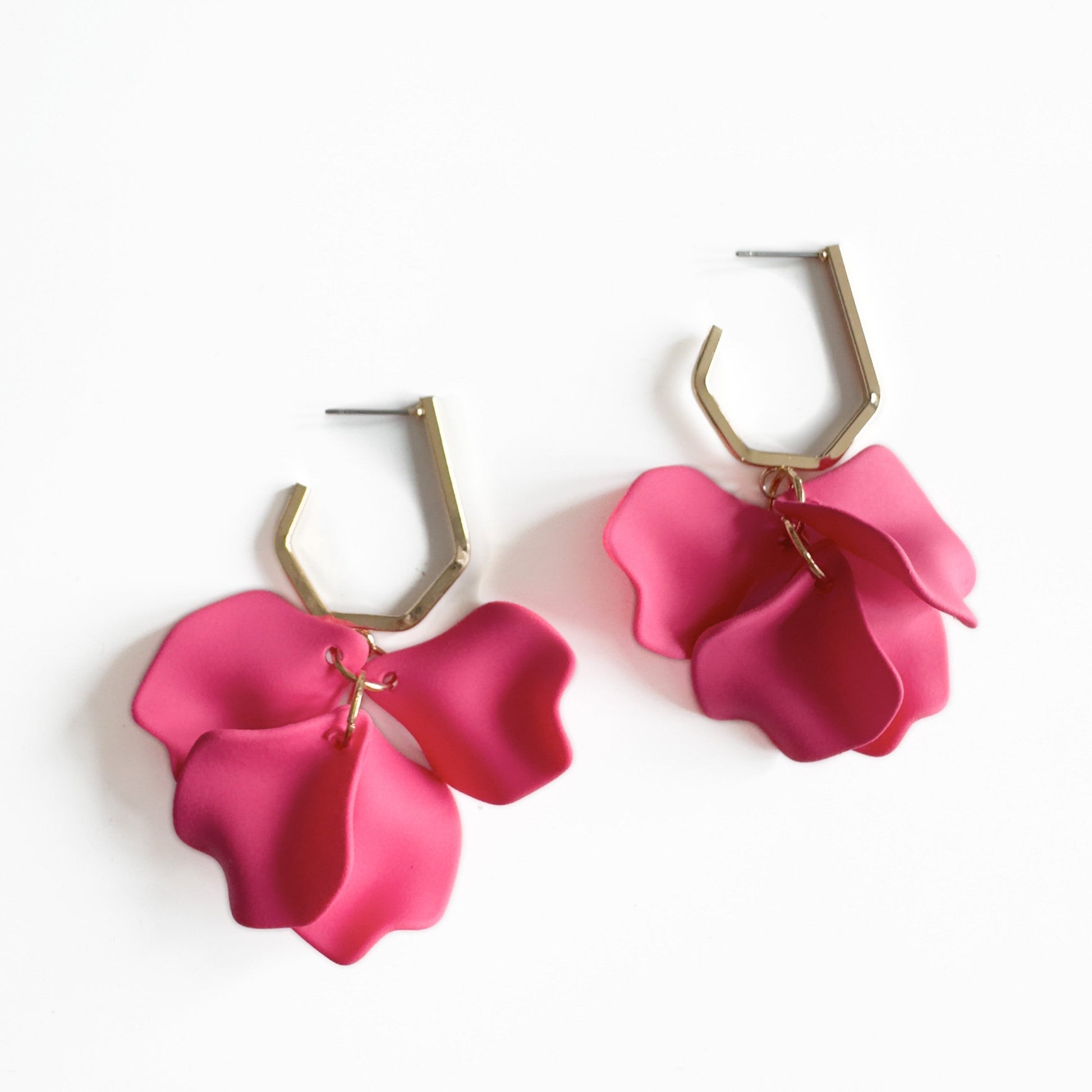 Bright pink Juni Ceries dangle earrings with petal design and gold-tone hexagonal hooks