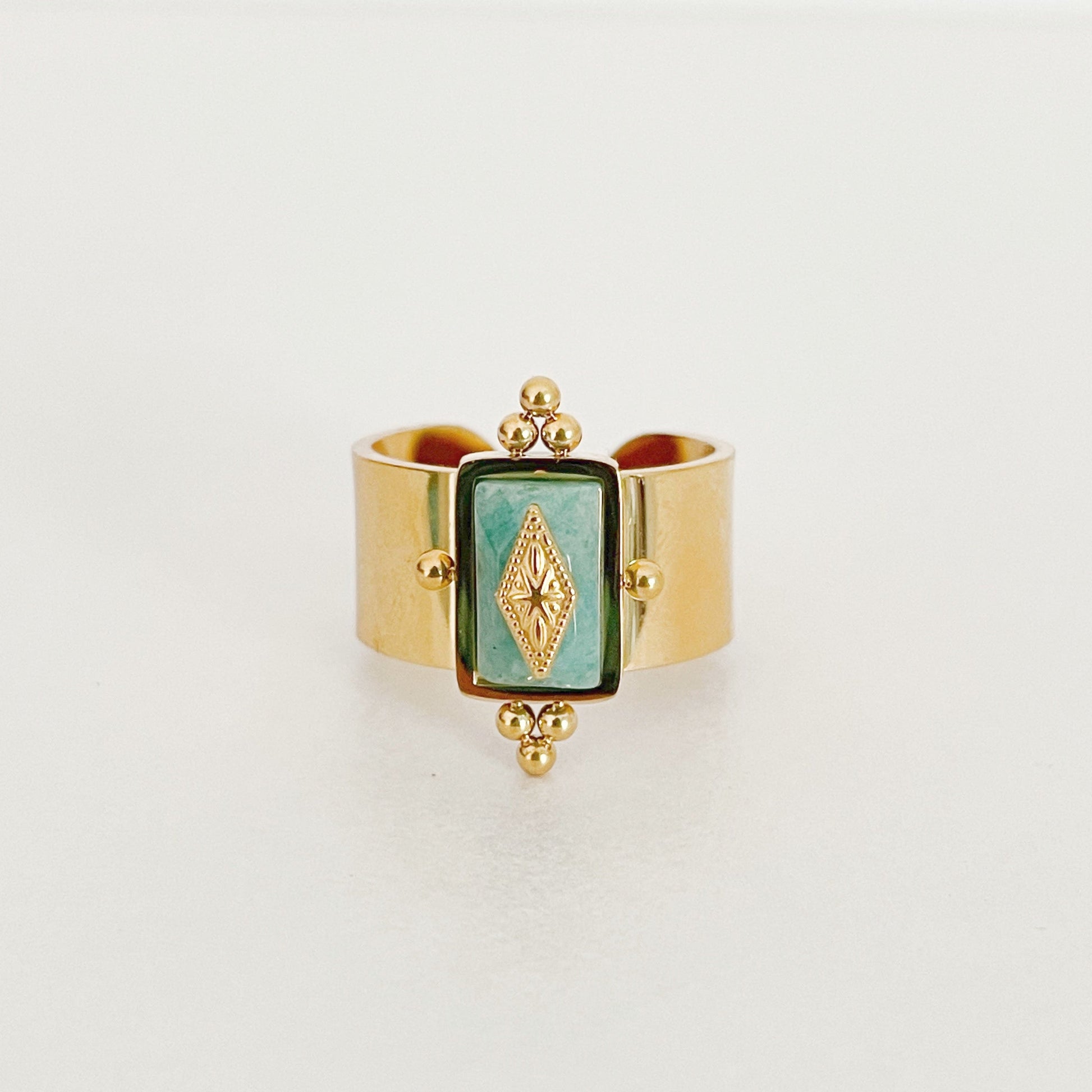 Gold plated Luna Wide Band ring with an irregular turquoise crystal centerpiece and decorative accents